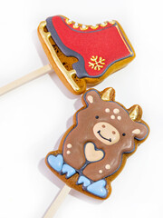 Christmas shaped gingerbread cookies on a stick. Gingerbread skates and gingerbread bull 2021 on a white background. Isolate