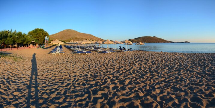 Sunset at Plati beach, Limnos, Greece. Sandy beach, footprints in the sand, calm sea, sunset.