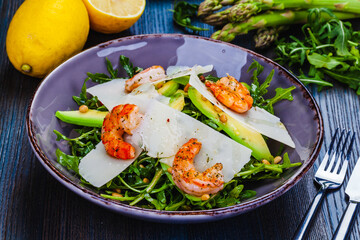Fresh salad bowl with arugula, avocado, shrimps, parmesan cheese and pine nuts. Healthy food. Diet menu.