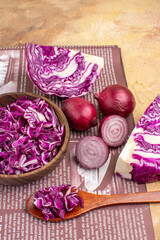 top view a concept with red onions and a bowl of chopped red cabbage for fresh homemade vegetable salad with copy space