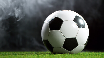 Fototapeta premium Soccer ball on lawn with smoke