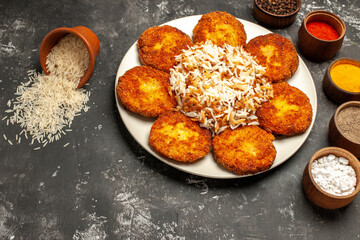 top view fried cutlets with cooked rice and seasonings on a dark background photo food meat dish
