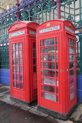 Fototapeta na wymiar two red telephone booths on the smith market in London