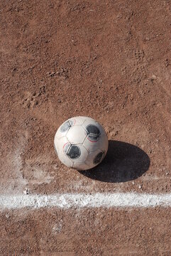 Ein Fussball liegt auf eine Ascheplatz mit einer wei&szlig;en Begrenzungslinie