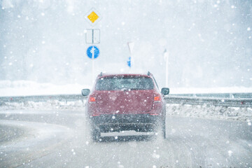 The car is driving on a winter road in a blizzard	