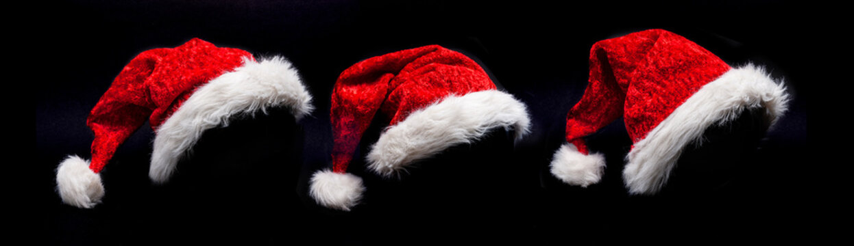 Drei Weihnachtsm&uuml;tzen vor schwarzem hintergrund