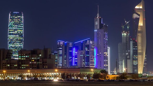 Kuwait City skyline with Skyscrapers day to night transition timelapse in downtown illuminated at dusk. Kuwait City, Middle East. View from road