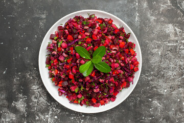 top close view salad with red vegtable in a white dish on grey background