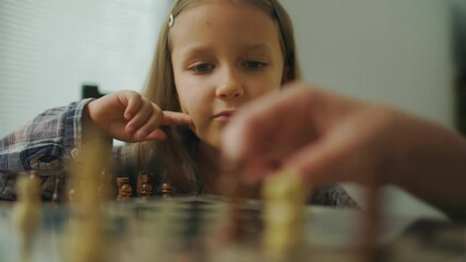 Young Man In Glasses Plays Chess With His Sister Girl At Home.