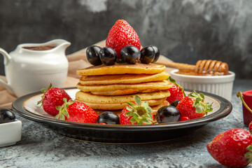 front view delicious pancakes with honey and fruits on light background sweet cake fruit