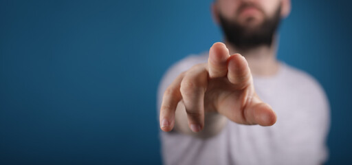 blue background young man finger pointing touch
