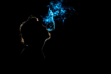 Colored silhouette of a smoking man on dark background.