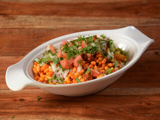 Bhel puri, a famous midday snack in india, served over a rustic wooden background, selective focus