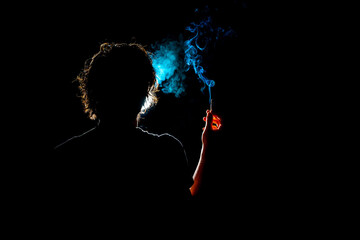 Colored silhouette of a smoking man on dark background.