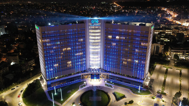 Aerial drone night shot of public Hellenic Telecommunication headquarters known as OTE and COSMOTE illuminated for Christmas holidays, &Alpha;thens, Attica, Greece