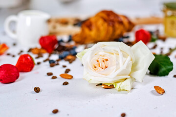 Breakfast includes croissants, fresh blueberries and chocolate on the wooden table.