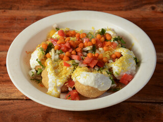 Dahi Puri a famous midday snack in india, served over a rustic wooden background, selective focus