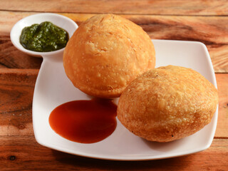 Kachori a famous midday snack in india, served over a rustic wooden background, selective focus