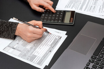 Woman filling tax form at office workplace.