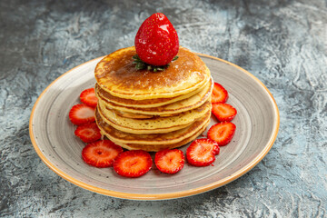 front view yummy pancakes with honey and strawberries on light background cake sweet fruit