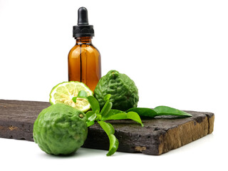 Bergamot essential oil herb with fruit and leaves on wooden background, isolated on white background.