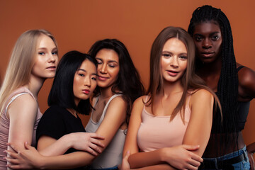 Obraz premium young pretty asian, caucasian, afro woman posing cheerful together on brown background, lifestyle diverse nationality people concept