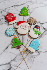 Christmas food: gingerbread on a stick. Deer, green christmas tree and red mitten cookies lay on the wight background
