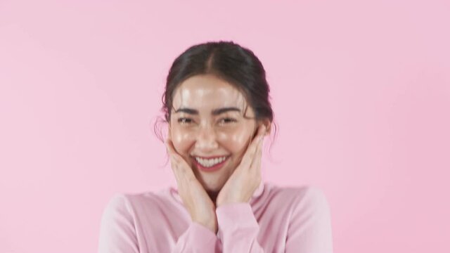 Beauty concept of 4k Resolution. Young Asian woman rejoicing on the pink background.
