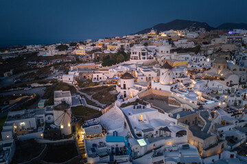 Oia town on Thira. Santorini island with colorful volcanic cliffs and deep blue sea aerial view