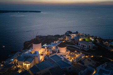Fototapeta premium Oia town on Thira. Santorini island with colorful volcanic cliffs and deep blue sea aerial view