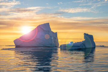 Iceberg extraordinary form at sunset in backlight rays of the sun in Antarctica. The beauty of Antarctica. Global warming.