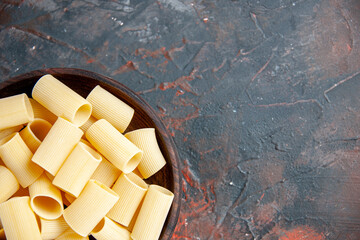 Fototapeta premium Half shot of uncooked pastas inside the pot on black background