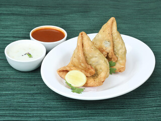Samosa, stuffed with mixed masala potatoes, Indian special traditional street food also known as punjabi samosa,aloo samosa.served over a rustic wooden background, selective focus