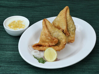Samosa, stuffed with mixed masala potatoes, Indian special traditional street food also known as punjabi samosa,aloo samosa.served over a rustic wooden background, selective focus