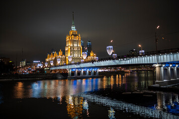 evening winter cityscape with river bridge and illuminated buildings