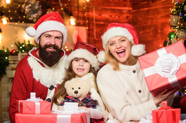 Fototapeta na wymiar Christmas is the time to please. Joyful people. Gifts from Santa. Lovely daughter with parents. Christmas traditions concept. Father Santa claus costume with mom and little kid celebrating christmas