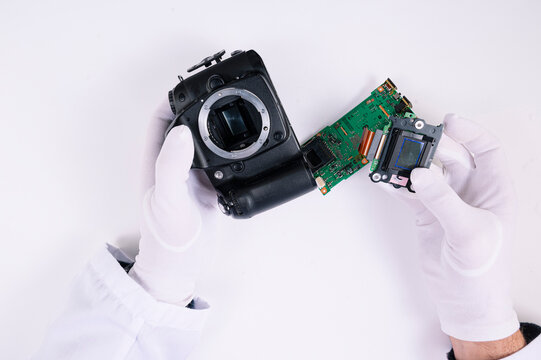 Engineer's hands repairing the camera in laboratory. Professional camera and lens maintenance support by engineer.