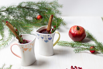 christmas mulled wine in heart shaped cups, spice, fruit, fir tree branches, new year decoration on white background