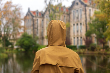 Woman on a yellow jacket with abandoned buildings old thermal hospital, lake and D. Carlos I park...