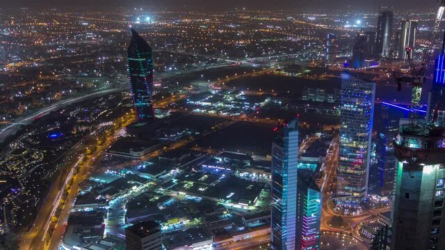 Skyline with Skyscrapers night timelapse in Kuwait City downtown illuminated at dusk. Aerial view from rooftop at foggy weather. Kuwait City, Middle East.