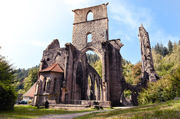 Fototapeta na wymiar Ruins of the All Saints abbey in the Black Forest near Oppenau, Germany on a sunny day. The former monastery is surrounded by forest.