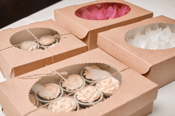 Cupcake packaging, delivery box, vanilla cupcakes with pink and white cream, selective focus, close up.