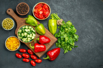 Fototapeta na wymiar top view of plate stand with vegetables over and near to it and with free place for text on dark greyish background