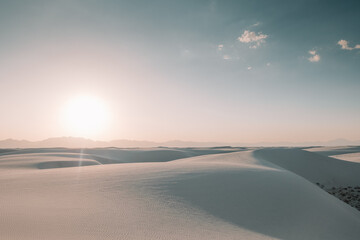The sun setting over the white gypsum sand dunes creating beautiful shadows and revealing textures in the sand at White Sands National Park, New Mexico, USA.