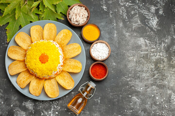 top view of salad with herbs oil bottle and leaves on side on dark grey table