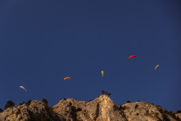 five colorful paraglider on blue sky in the mountains with a skywalk
