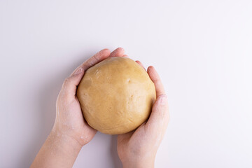 gingerbread dough in hands with flour on a white background