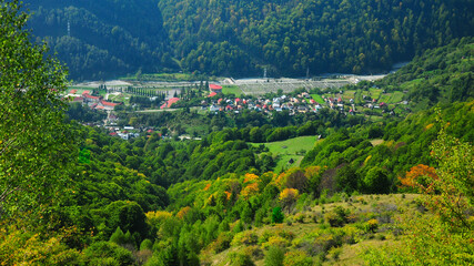 View above a traditional easter european village found in the forested hills of Carpathian Mountains, Romania. Ciungetu, Latorita Mountains - autumn season.