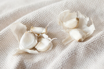 Fototapeta na wymiar Garlic on white napkin. Eating garlic is claimed to fight infections, has an antiseptic, antibacterial, and anti-fungal agent. It helps the body resist or destroy viruses and other microorganisms.