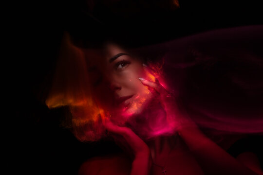 Girl, model photographed on a long exposure in the studio with color filters. Portrait